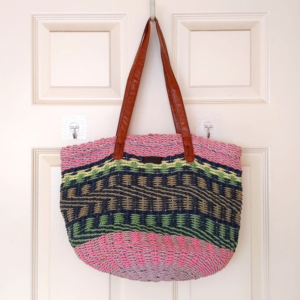 NWOT. Kbas Multi color design straw tote bag with lining and pockets.